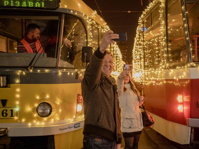 Local residents take photos near trams decorated for Christmas in one of the central streets of Kharkiv, on December 24, 2024, amid the Russian invasion in Ukraine. Picture: AFP