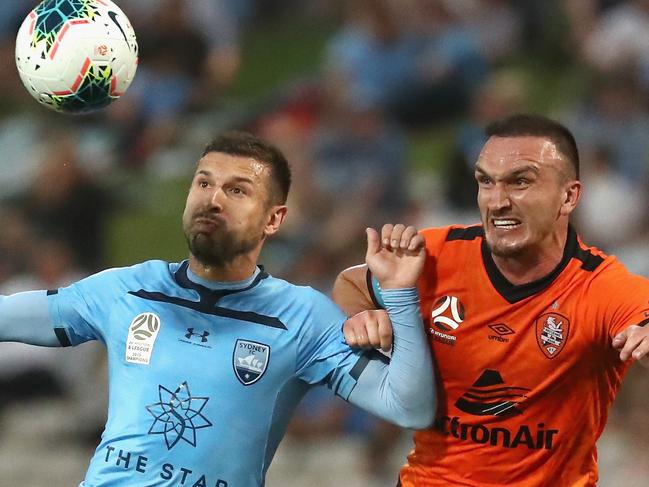 Kosta Barbarouses of Sydney FC and Captain of the Roar Tom Aldred challenge for the ball during the Round 9 A-League match between Sydney FC and Brisbane Roar at Netstrata Jubilee Stadium in Sydney, Saturday, December 7, 2019. (AAP Image/Jeremy Ng) NO ARCHIVING, EDITORIAL USE ONLY