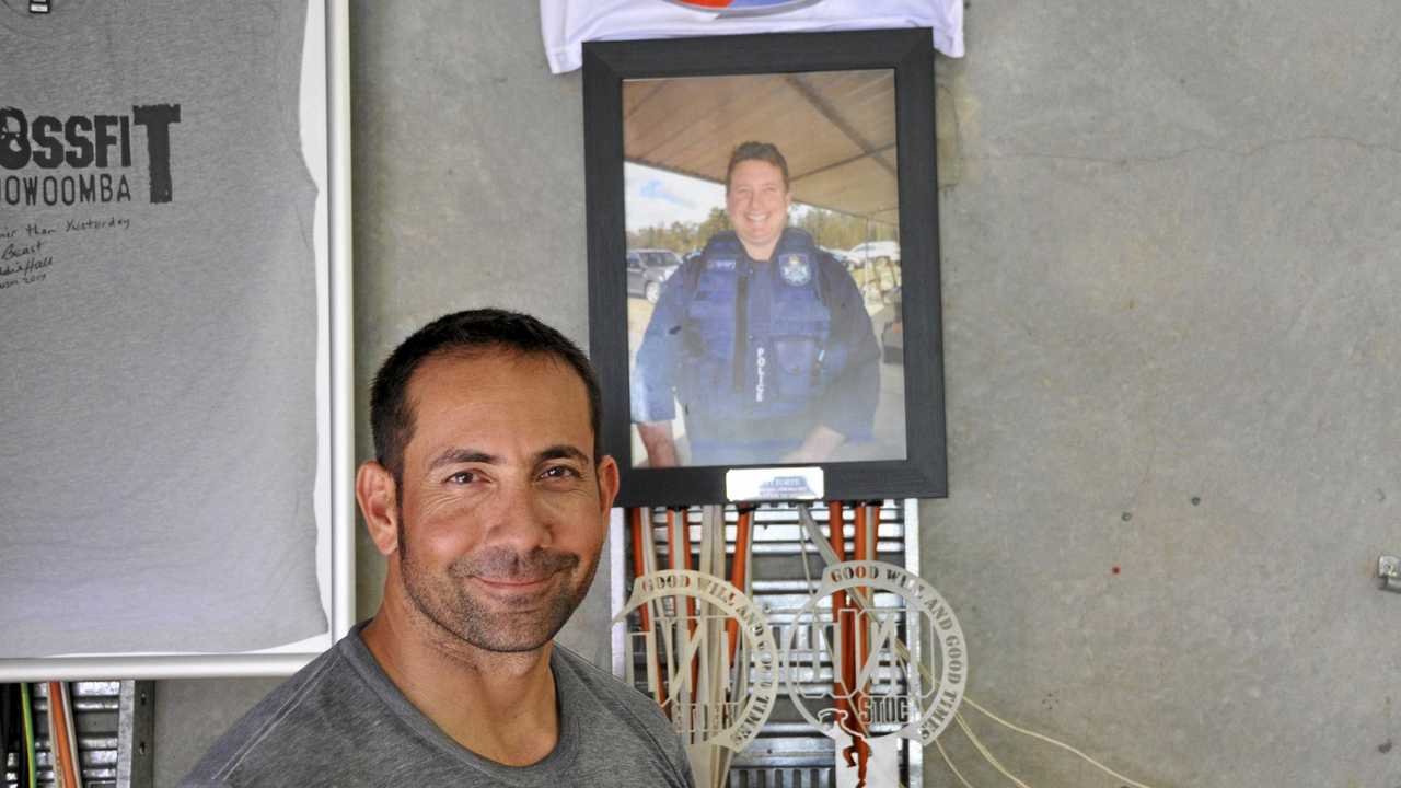 SPECIAL TRIBUTE: CrossFit Toowoomba owner Kent Strout stands in front of the gym's Senior Constable Brett Forte memorial. Picture: Jason Gibbs