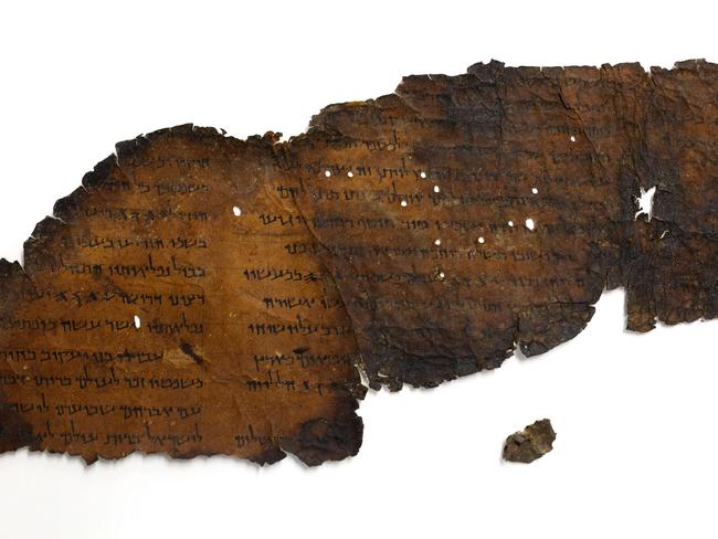 A picture taken on May 2, 2018 at the Israel Antiquities Authority's Dead Sea scrolls conservation laboratory in Jerusalem shows a large fragment of a scroll found in "Cave 11", next to another small fragment which recently with the aid of advanced imaging equipment revealed a previously unseen hidden text. The Dead Sea Scrolls are a collection of hundreds of biblical texts in Hebrew, Aramaic, and Greek discovered 45 years ago in the Qumran Caves near the Dead Sea. / AFP PHOTO / GALI TIBBON