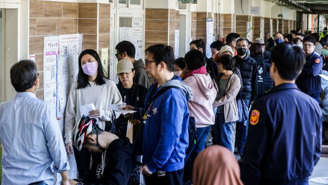 People wait in line to cast their ballots and vote in the presidential election at a polling station in Taipei on Saturday. Picture: AFP