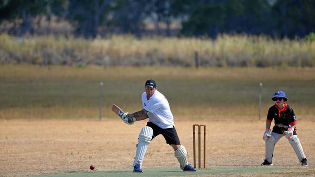 Adam Cummins changes his grip to go for a right-handed sweep at Wheatvale on Saturday. Hugh Inmon is keeper on a field where the drought is very evident. Picture: Gerarda Walsh