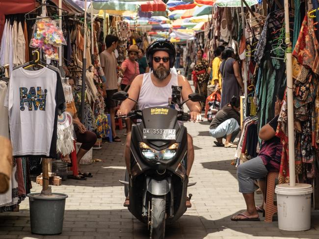 UBUD, BALI, INDONESIA - DECEMBER 8: A foreign tourist rides motorbike at the Ubud street art market on December 8, 2022 in Ubud, Bali, Indonesia. Indonesia's parliament voted to pass a law that bans extramarital sex on Tuesday, in a move that critics quoted in local media have said will severely impact the tourism industry. Regions like Bali rely heavily on an influx of foreign tourists to keep their economies afloat, and the new law has raised concerns just as international arrivals start to pick up again post-pandemic.  (Photo by Agung Parameswara/Getty Images)