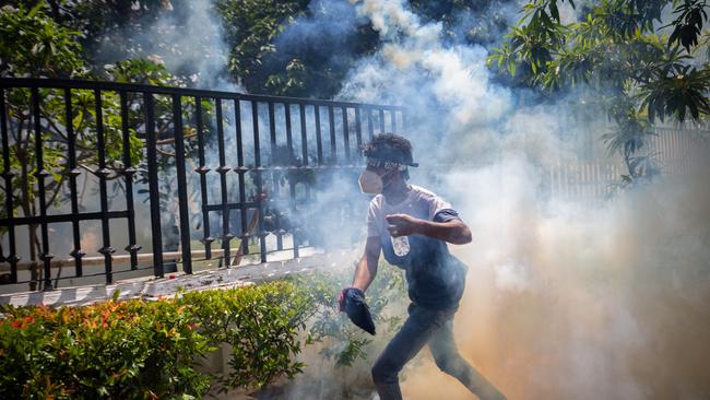 A protester runs for cover from a tear gas canister fired by army personnel during a protest seeking the ouster of Sri Lanka's Prime Minister Ranil Wickremesinghe. Sri Lanka is a terrifying example of where contemporary currents of politics can lead a nation.