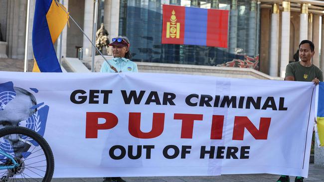 People holding Ukranian national flags and a banner take part in a protest ahead of a visit by Vladimir Putin in Ulaanbaatar, Mongolia's capital. Picture: AFP.