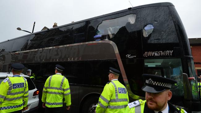 The bus carrying the Manchester United team is escorted by police after having a window smashed.