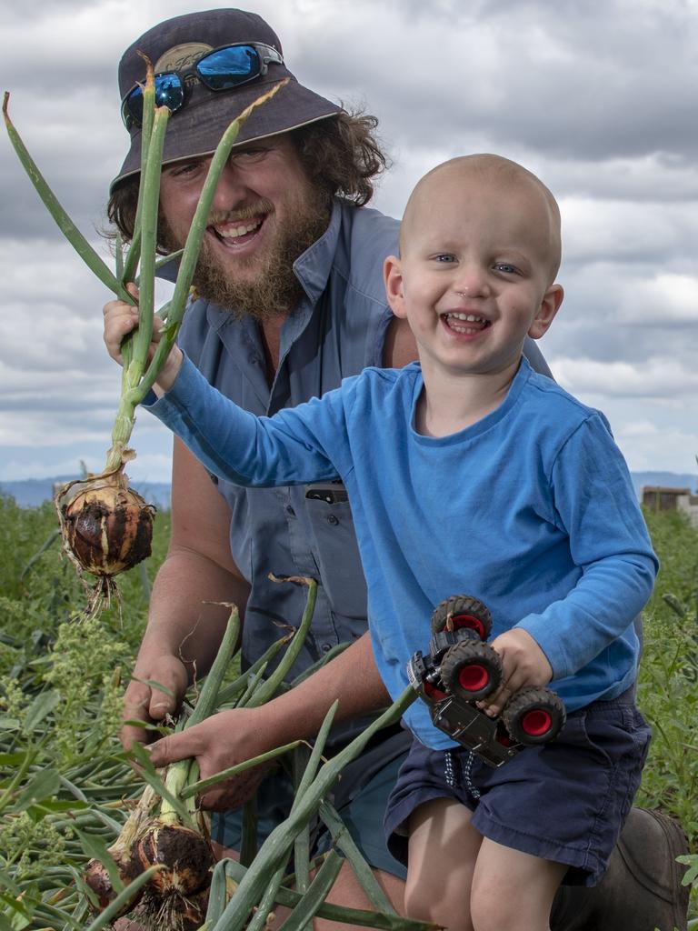 Andrew Mildren, Reck Farms, Lower Tent Hill, with his son Cooper, 2, inspecting some onions.