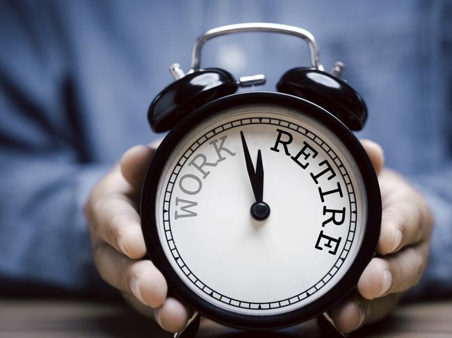 Businessman holding black alarm clock with clockwise countdown from work to retirement.