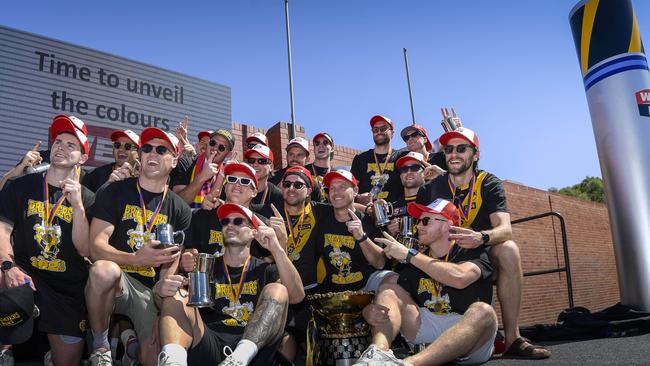 Glenelg’s 2023 SANFL premiership team celebrates the black and gold colours being unveiled at the top of the Hoffmann Kiln at Brickworks Marketplace. Picture: Roy VanDerVegt