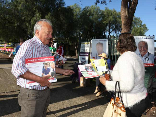 Dr Mike Freelander hands out how to vote cards at Ingleburn Public School. Picture: Robert Pozo