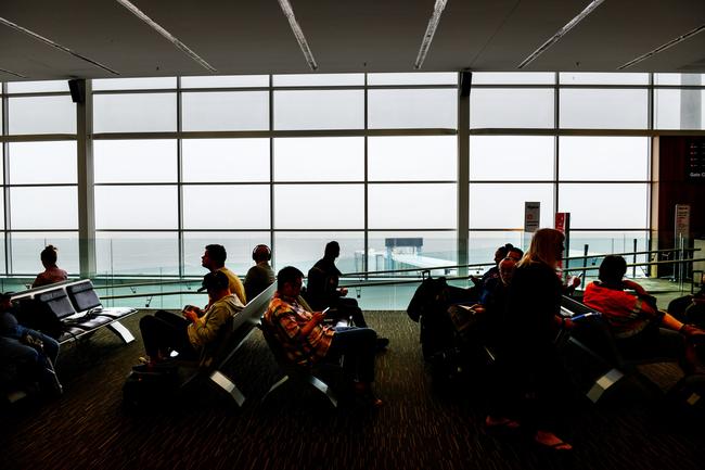 Travellers wait at Adelaide Airport for their flights to arrive. Picture: AAP / Brenton Edwards