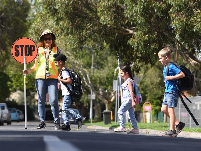 Crossing supervisor Silvana Vennerdo watches (l-r) Raj Singh (6), Ayla Eryegit (5) and (6) Angus Hay (7) cross the road at St Bernard's Primary in Coburg, Friday, January 24, 2020. (Photo/Julian Smith)