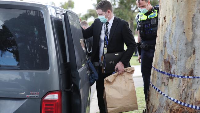 Police leave with evidence bags.