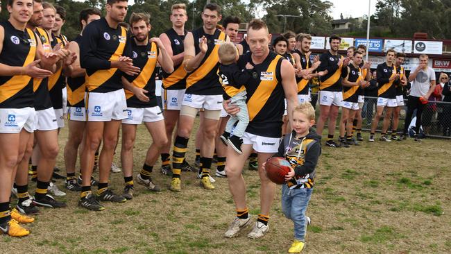 s01hb202 NFL (Div 1) football: Lower Plenty v Heidelberg Blair Harvey runs out for his 300th game with sons Brax in arms and Hunter with ball.