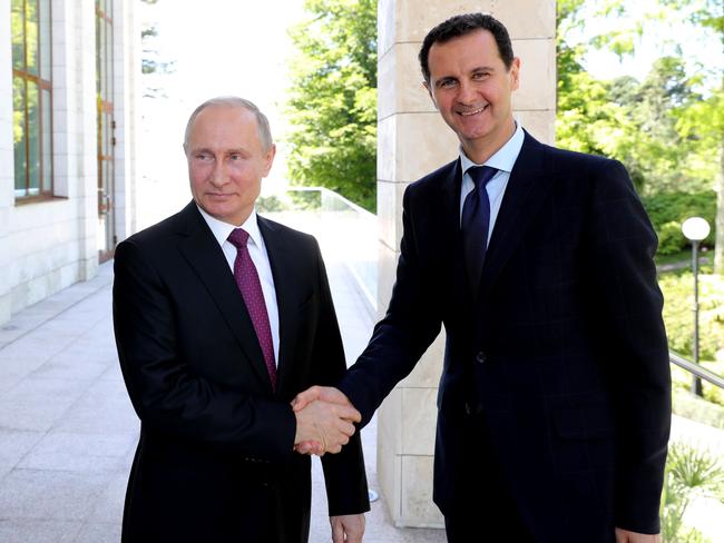 Russian President Vladimir Putin (L) shakes hands with his Syrian counterpart Bashar al-Assad during their meeting in Sochi on May 17, 2018. / AFP PHOTO / SPUTNIK / Mikhail KLIMENTYEV