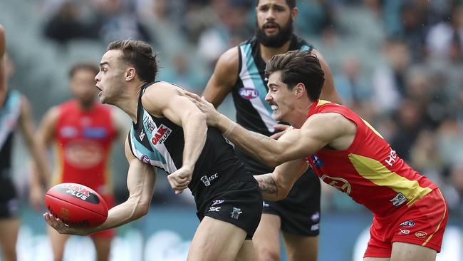 Port Adelaide’s Karl Amon under pressure from Gold Coast’s Alex Sexton. Picture Sarah Reed