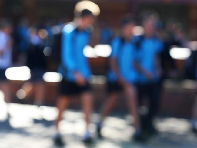 Deliberate extreme blur of students to hide identity walking in the school yard chatting between lessons stock photo