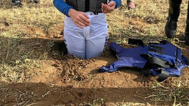 A jockey stands in the sinkhole which opened up on the Calliope racetrack during a race meeting last Saturday.