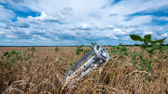 A fragment of a rocket from a multiple rocket launcher is embedded in the ground on a wheat field in Ukraine.