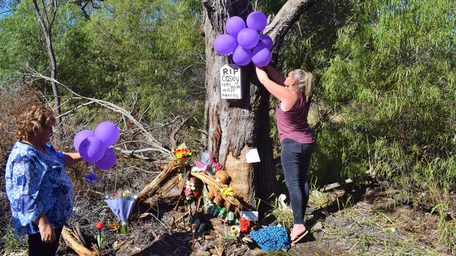 FLY HIGH: Clinton’s mother Robin, and Teresa at the Chinchilla Tara Rd memorial site putting up balloons in Clinton favourite colour - purple. Pic: Peta McEachern