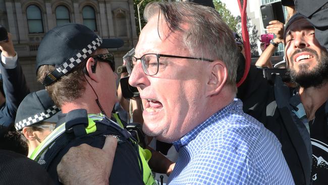 A man yells abuse at Cardinal George Pell outside court. Picture: AAP Image/David Crosling