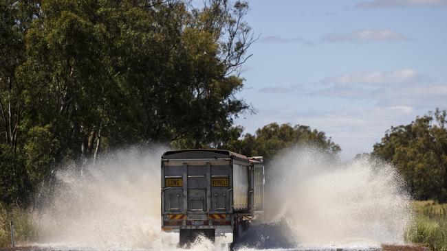 A truck speeds through flood waters on Henry Lawson Way near Forbes in Central West NSW. The Bureau of Meteorology is predicting possible major flooding at Forbes. Picture: Brook Mitchell/Getty Images