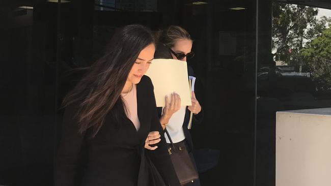 Rebecca Jane Klodinsky, hiding her face behind a manilla folder, pleaded guilty to stealing in the Southport Magistrates Court. Picture: Jodie Callcott.