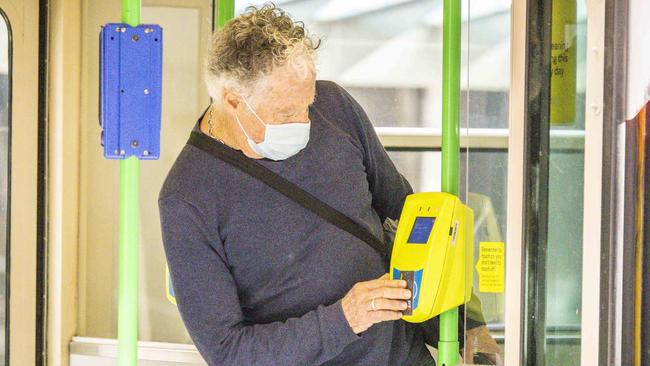 A man wears a surgical face mask on public transport in Melbourne. Picture: Wayne Taylor