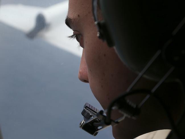 FILE - In this March 22, 2014 file photo, Sgt. Matthew Falanga on board a Royal Australian Air Force AP-3C Orion, search for the missing Malaysia Airlines flight MH370 in southern Indian Ocean, Australia. The hunt for Malaysia Airlines Flight 370 will be suspended once the current search area in the Indian Ocean has been completely scoured, the ministers of the three countries conducting the operation announced Friday, possibly ending all hopes of solving aviation's greatest mystery. (AP Photo/Rob Griffith, File)