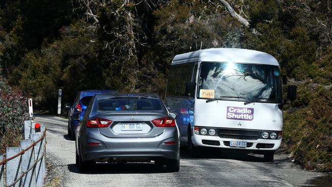 Private cars and a shuttle bus squeeze past each other on the narrow winding road into Dove Lake. Picture: CHRIS KIDD