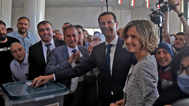 Syrian President Bashar al-Assad, centre, and his wife Asma, right, cast their votes at a polling station in Douma, near Damascus on May 26, 2021. Picture: LOUAI BESHARA/AFP)