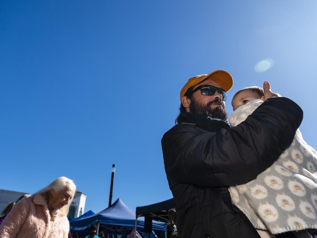 Aaron and baby Amahni Blades emerge from the smoke at the Smoking Ceremony at the NAIDOC arts and craft market at Grand Central, Saturday, July 9, 2022. Picture: Kevin Farmer