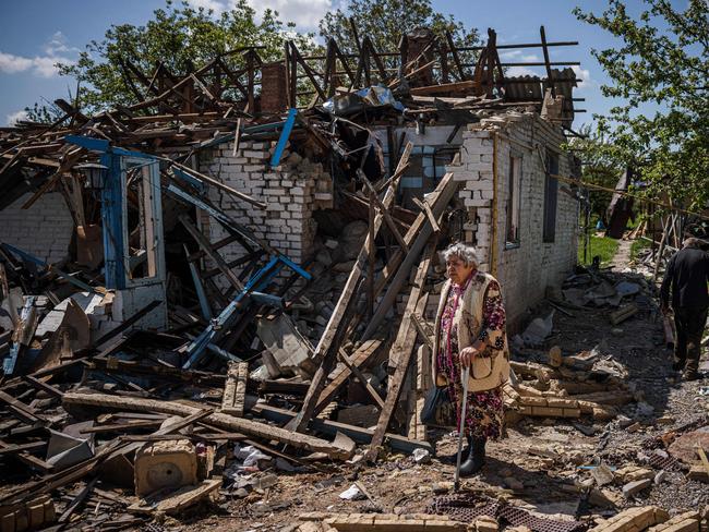 A couple brings their luggage out of their destroyed house in the village of Vilkhivka, near the eastern city of Kharkiv. Picture: AFP