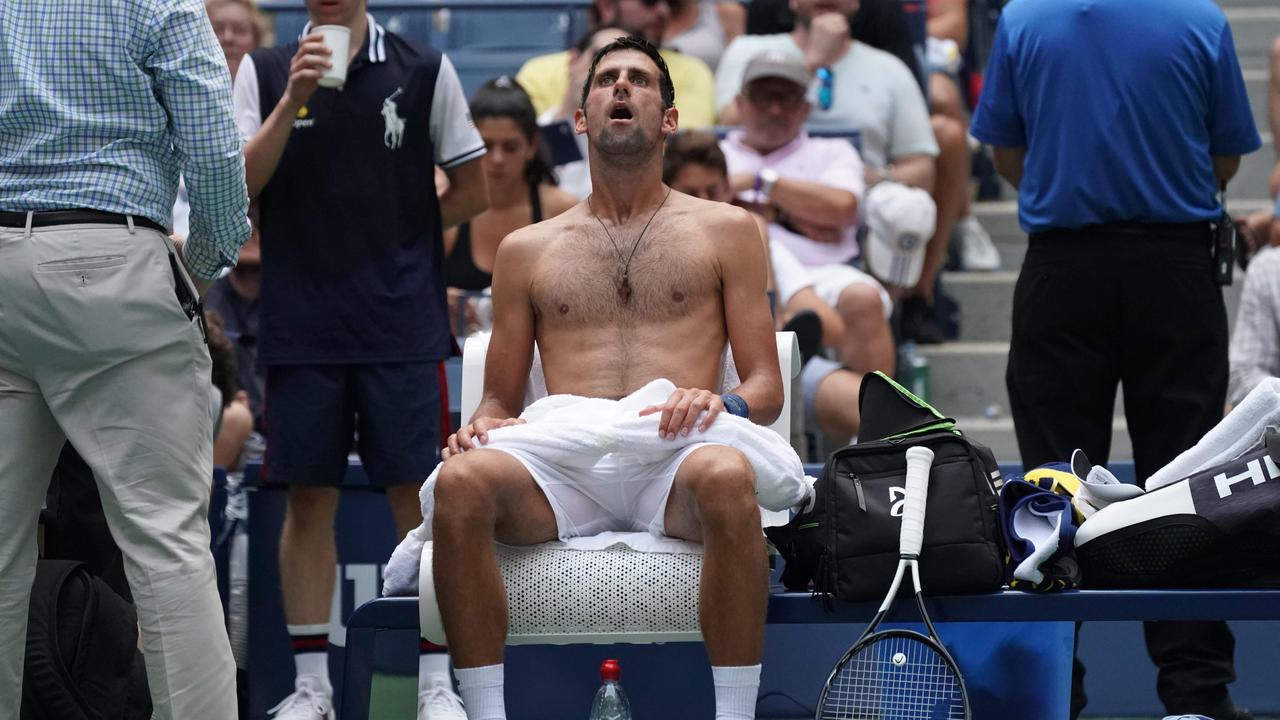 Novak Djokovic of Serbia takes a break from the heat.