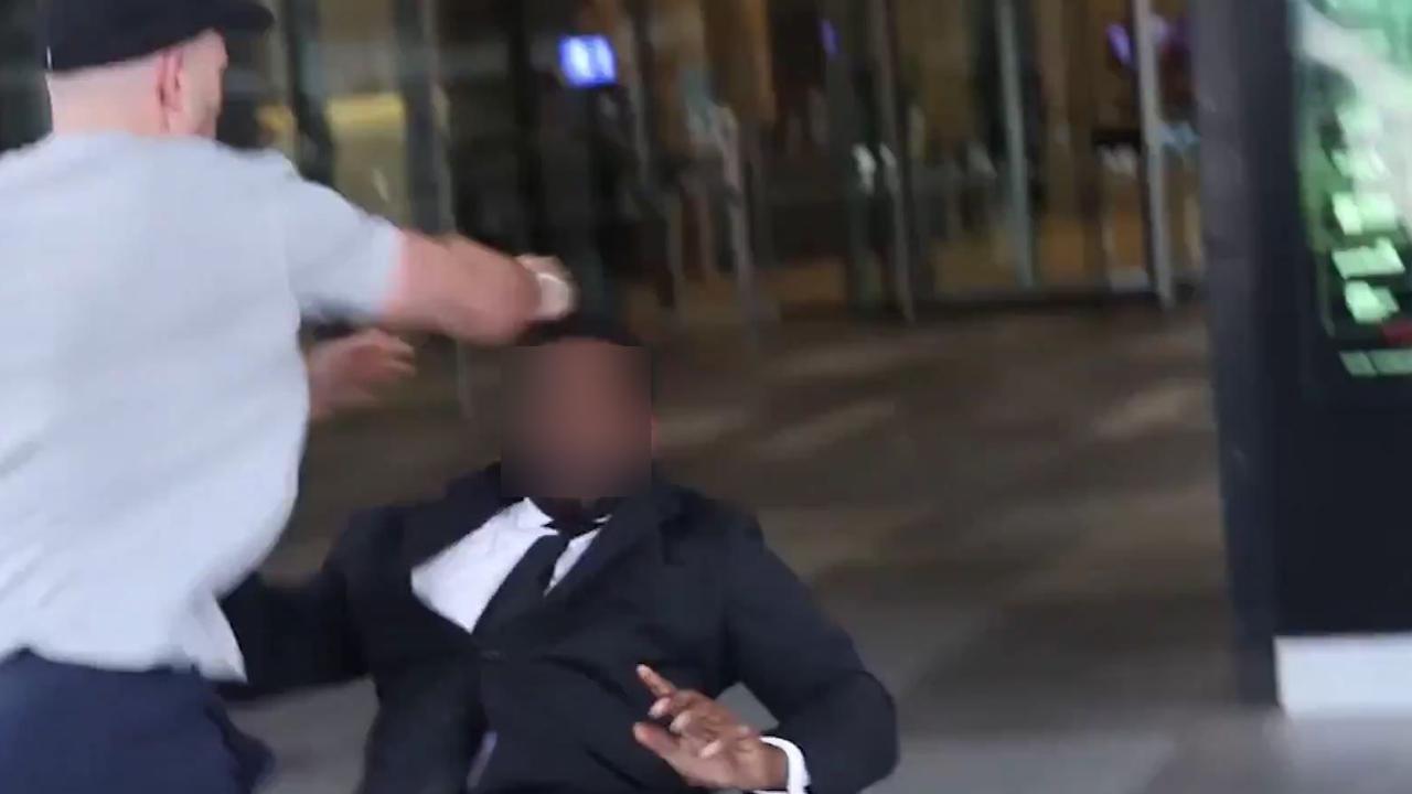 The security guard falls backwards after allegedly being attacked.