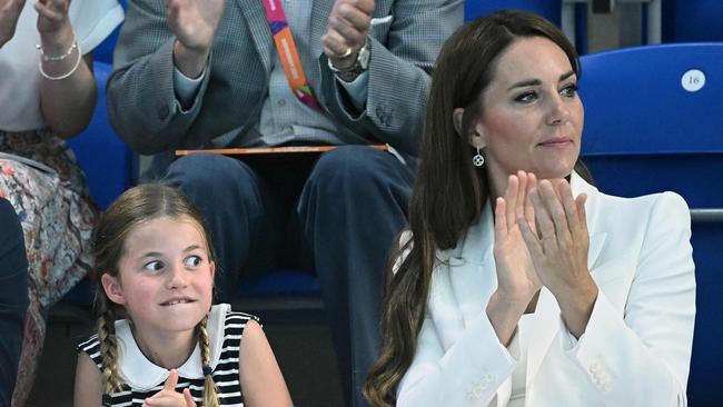 Britain's Princess Charlotte of Cambridge (L) reacts as she sits with her mother Britain's Catherine, Duchess of Cambridge to watch the men's 1500m freestyle heats swimming event at the Sandwell Aquatics Centre, on day five of the Commonwealth Games in Birmingham, central England, on August 2, 2022. (Photo by Oli SCARFF / AFP)