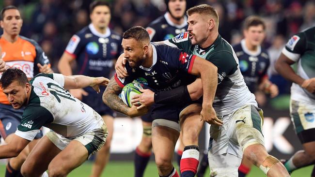 Rebel five-eighth Quade Cooper is tackled by Bulls defender Paul Tier Schoeman. Picture: AFP