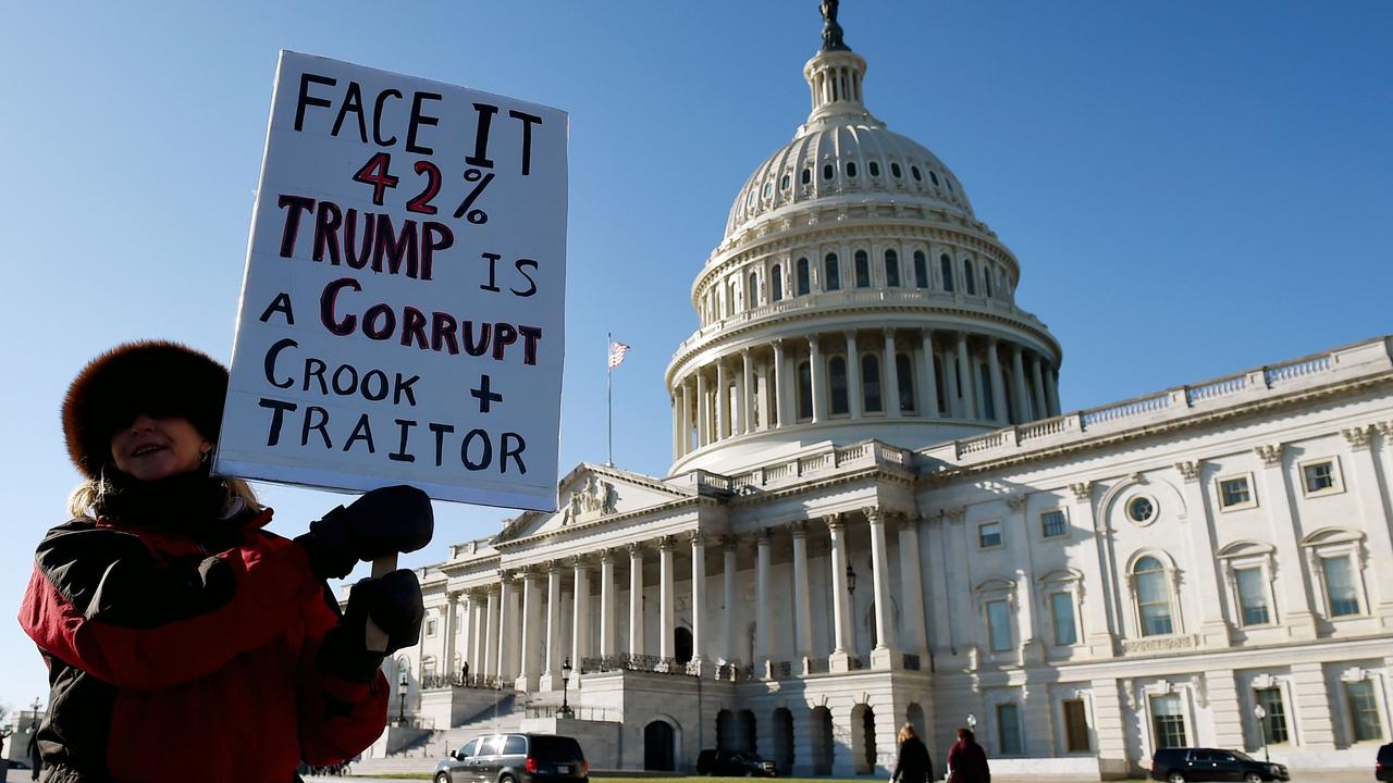 People carried signs reading “criminal-in-chief” and “save the constitution at the rallies. Picture: Olivier Douliery / AFP.