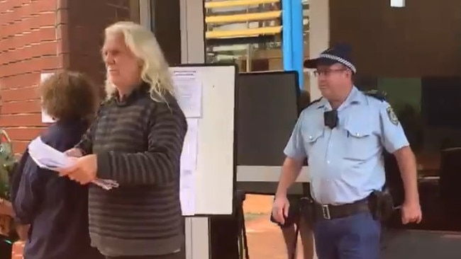 John Anderson being escorted from the Byron Shire Council chambers in Mullumbimby during the April 2021 ordinary meeting. Picture: Liana Boss