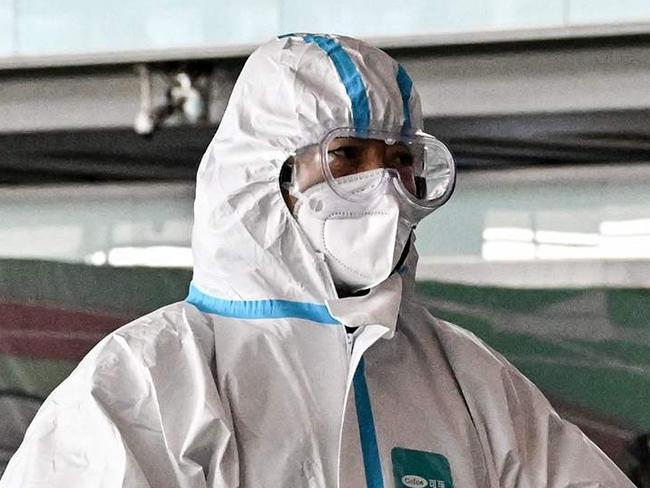 A passenger, wearing a personal protective equipment, walks at the arrival area at the Capital International Airport in Beijing on January 8, 2023. China lifted quarantine requirements for inbound travellers on January 8, ending almost three years of self-imposed isolation even as the country battles a surge in Covid cases. (Photo by Noel CELIS / AFP)