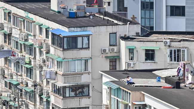 A resident sits near the edge of a rooftop of a building during the second stage of the Covid-19 pandemic lockdown in Shanghai. Picture: Hector Retamal/AFP