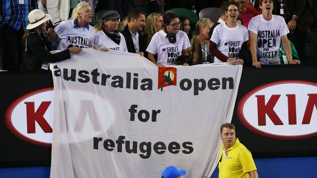 Demonstrators protest for refugees during the men's final match last night.