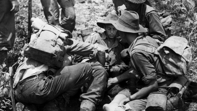 An Australian soldier receives treatment after the dawn attack on the Japanese-held village of Sattelberg, New Guinea on November 23, 1943. Picture: Department of Information G940.542