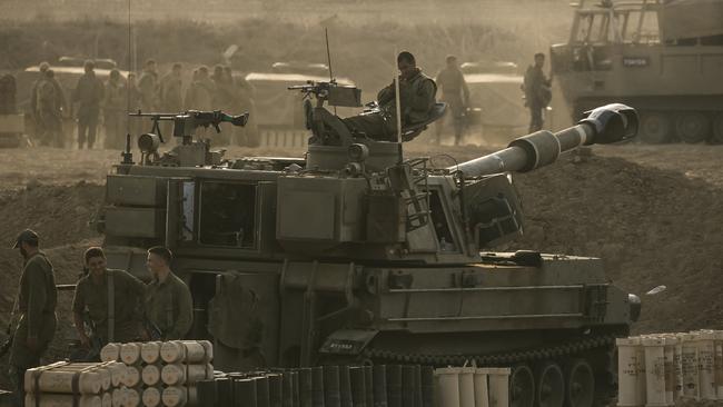 IDF soldiers sit on an artillery unity near the Israeli border with the Gaza Strip as Israel prepares to invade in its campaign to vanquish Hamas.