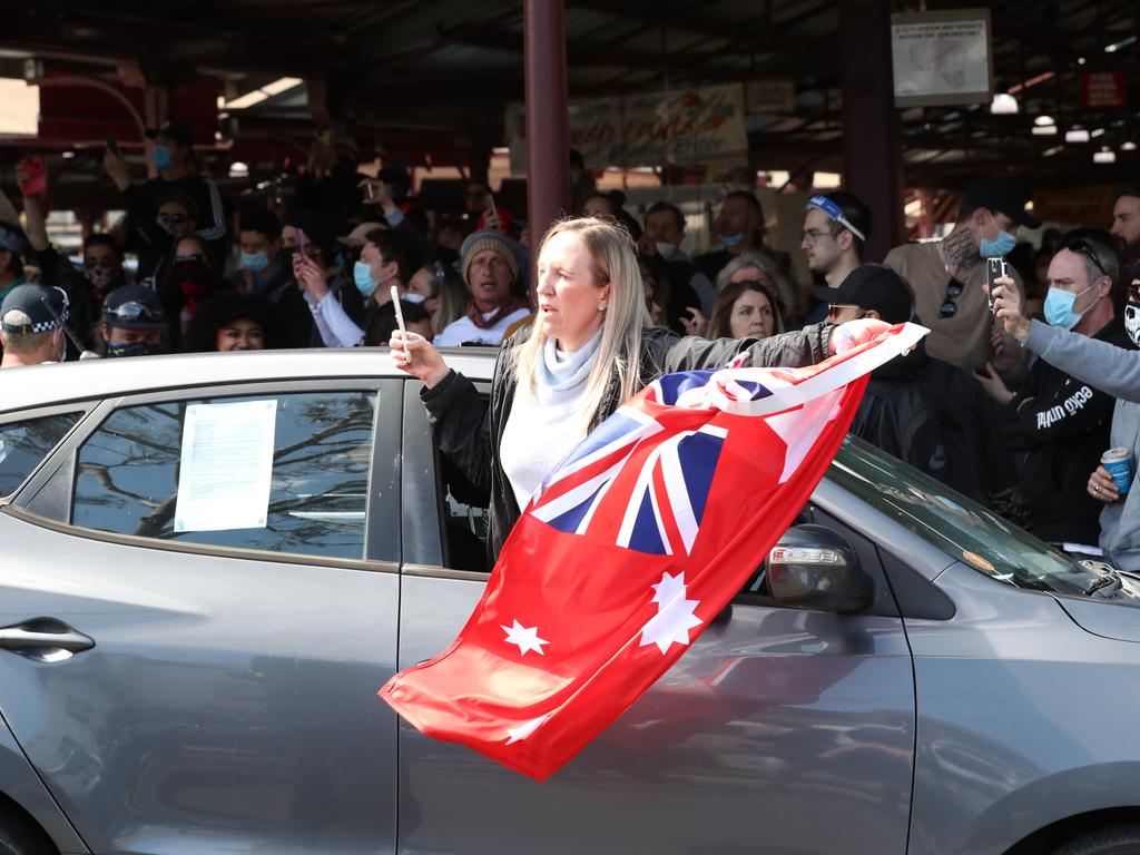 A woman waves a flag out the window of a car. Picture: David Crosling