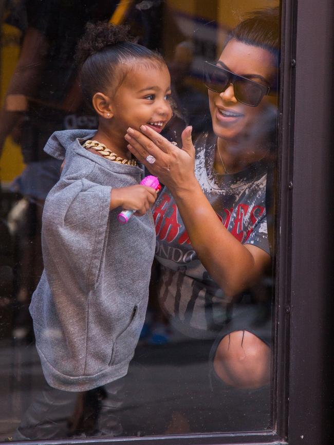 North West giggles and makes faces through the glass. Picture: Splash