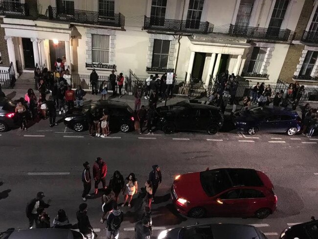 Revellers hang out the front of the tiny Kensington flat. Picture: Chris Eades