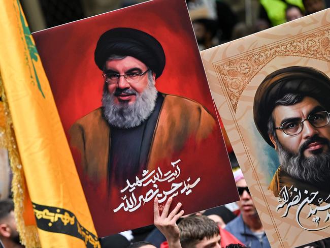 Demonstrators hold flags and pictures of Hassan Nasrallah, late leader of the Lebanese group Hezbollah, at a protest rally in the central business district of Sydney on September 29, 2024. (Photo by Saeed KHAN / AFP)