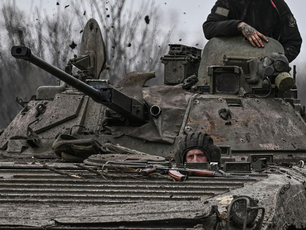 A Ukrainian serviceman looks on as he drives a BMP-2 tank while moving towards the city of Bakhmut. Picture: Aris Messinis / AFP