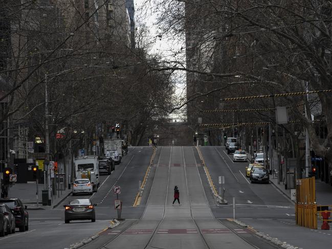 A person crosses a quiet Collins St on July 24, 2021 in Covid-stricken Melbourne. Picture: Getty